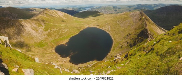Natural panoramic landscape from Helvellyn Edge, and the small lake Red Tarn, in the Lake District National Park, Northern England, Cumbria county, UK