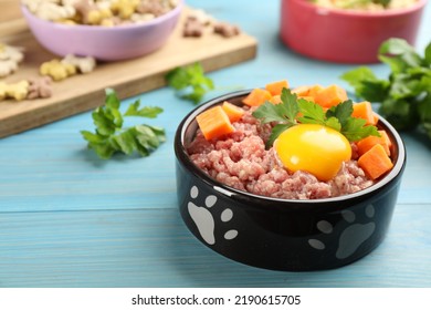 Natural pet food in feeding bowl on light blue wooden table, closeup. Space for text - Powered by Shutterstock