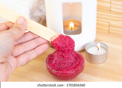 Natural Pink Body Scrub Made From Sugar. Pink Scrub In A Glass Cup On A Background Of Candles And Sugar.