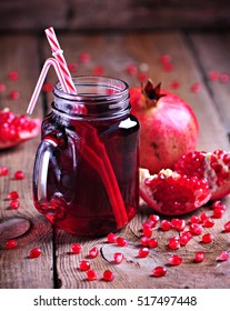 Natural pomegranate juice in a Mason jar on the old wooden background. Healthy food.