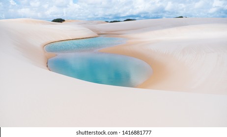 Natural rainwater pool in Lencois Maranhenses National Park, Maranhao, Brazil white sand dunes desert with blue and green lagoons. Remote holiday idyllic destination.