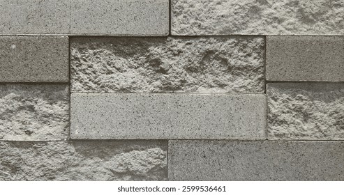 Natural rectangular cut cobblestone brick wall style texture in grey tone colors.