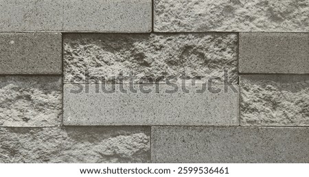 Natural rectangular cut cobblestone brick wall style texture in grey tone colors.