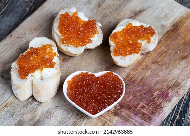 natural red salmon caviar with baguette and butter, making sandwiches snacks from red caviar, baguettes and butter