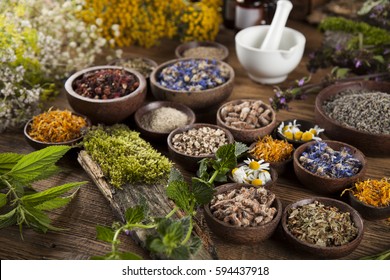 Natural remedy and mortar, healing herbs background - Shutterstock ID 594437918