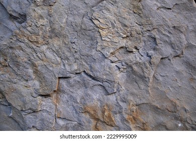 A natural rock wall with various cracks and furrows - Powered by Shutterstock