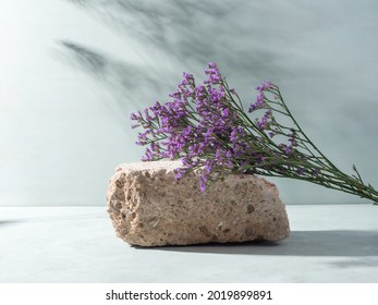 Natural Rough Gray Stone Podium With Purple Flowers And Hard Light Shadows On Teal Background. Minimal Creative Composition Design Scene, Mockup For Product Display