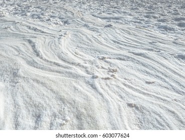 Natural salt texture on the coast of the lake at oasis Bahariya, white desert in Egypt. Abstract nature pattern of mineral salt for your white background. Wavy relief on the shore of lake surface.