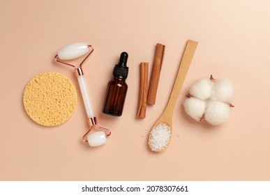 Natural Skin Care Concepts Of Cosmetic Oil, Glass Bottle, Serum, Gua Sha, Sea Salt, Sponge On Beige. Space For Text. Top View.