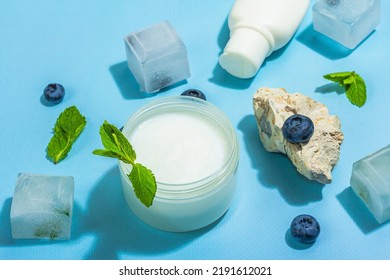 Natural Skincare. Cream Or Lotion With Organic Berries. Blueberry, Mint, And Ice. Moisturizing And Tonic Cosmetics Concept, Flat Lay, Trendy Hard Light, Dark Shadow, Blue Background, Close Up