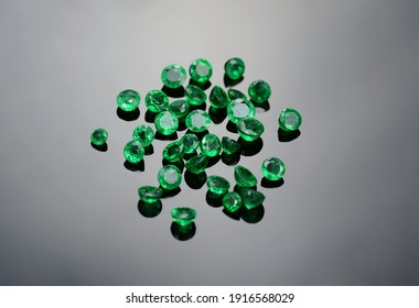 Natural small round shaped muzo mine colombian emeralds for making jewelry in semidark gray gradient background. Closeup makro gemstones. - Shutterstock ID 1916568029