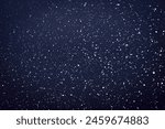 Natural snow particles in the air. Dark blue fading to black background. High quality photo