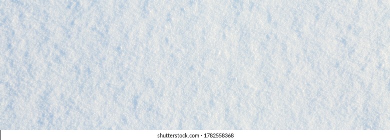 Natural snow texture. Smooth surface of clean fresh snow. Snowy ground. Winter background with snow patterns. Closeup top view. Wide panoramic texture for background and design.