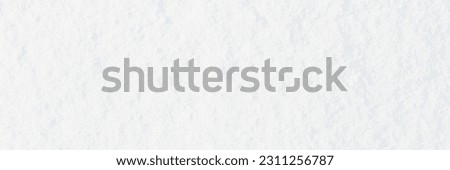 Natural snow texture. Smooth surface of clean fresh snow. Snowy ground. Wide panoramic winter background with snow patterns. Perfect for Christmas and New Year design. Closeup top view.