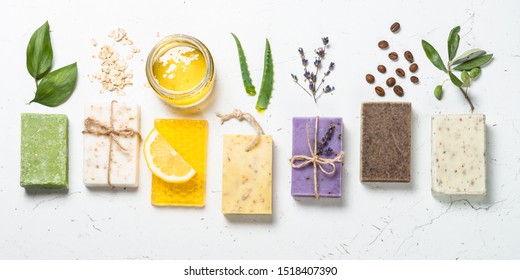 Natural soap bars with ingredients. Aloe, lavender, eucalyptus, olive, honey, coffee, tee tree oil and oat soaps. Top view with copy space. - Powered by Shutterstock