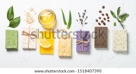 Natural soap bars with ingredients. Aloe, lavender, eucalyptus, olive, honey, coffee, tee tree oil and oat soaps. Top view with copy space.