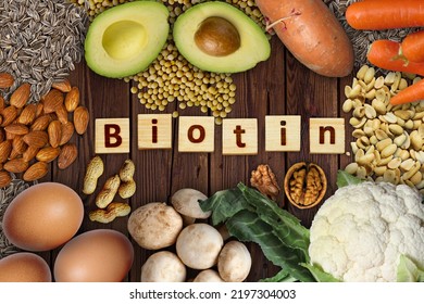 Natural Sources Of Biotin (vitamin B7) . Foods As Avocado, Eggs, Soybeans, Cauliflower, Carrot, Sweet Potato, Mushrooms, Peanuts, Walnuts, Sunflower Seeds And Almonds On Wooden Table.