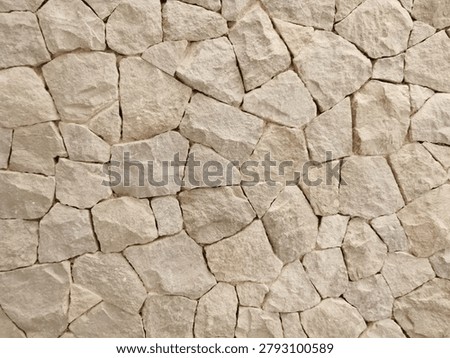 Natural Split Stone Cladding Wall Texture for Exterior Facade, Background. Close up texture of natural split-face stone cladding or palimanan stone wall. This rustic, beige colored material is commonly used for exterior facades of tropical villas, resorts, and modern Balinese architecture. Seamless texture background for architectural and design content.
