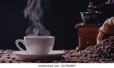 Natural Steamed Coffee Smoke From A Coffee Cup, Hot Drink. Close-up Hot Coffee Mug With Realistic Nature Steam Raising Smoke With Vintage Grinder On Dark Background. Food And Drink Concepts