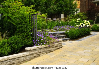 Natural stone landscaping in front of a house with lush green garden