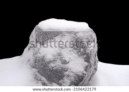 natural stone in snow isolated on black background. High quality photo
