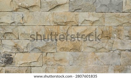 natural stone wall featuring rectangular sandstone blocks in rustic beige, yellow and brown tones