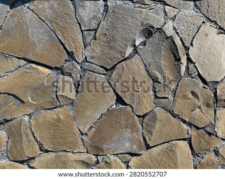 Natural stone wall texture with irregular slate pieces and cement joints. Rustic architecture background pattern.
Top view of irregular natural stone wall with brown and gray slate pieces. Rough masonry texture for exterior construction, landscaping, and rustic architecture. Seamless background. Vertical photo.