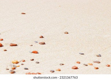 Natural stones amber yellow colored on beige sand. Aesthetic minimal nature scene with pebble stones on fine sandy background. Summer vacation or relaxation concept, selective focus, copy space - Powered by Shutterstock