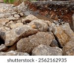 Natural stones arranged on rugged terrain with red soil, showcasing the raw beauty of nature