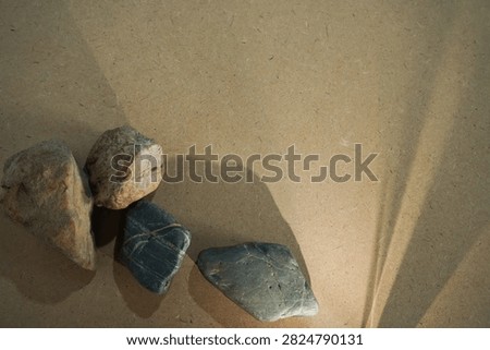 Natural stones and dramatic sunlight shadow on wooden board back
