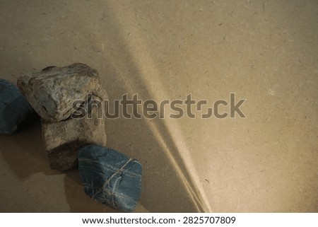 Natural stones and dramatic sunlight shadow on wooden board back