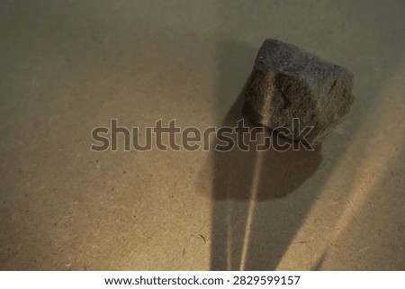 Natural stones and dramatic sunlight shadow on wooden board back