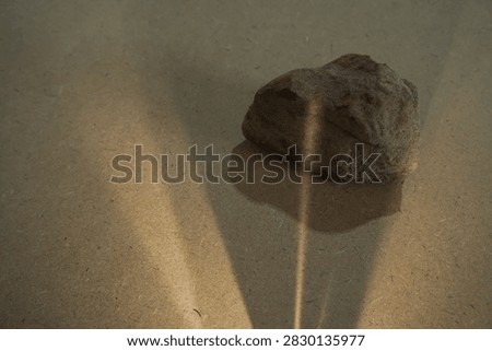 Natural stones and dramatic sunlight shadow on wooden board back