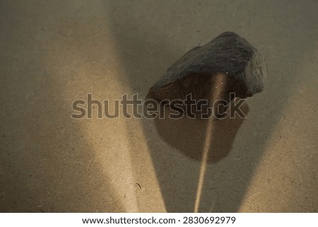 Natural stones and dramatic sunlight shadow on wooden board back
