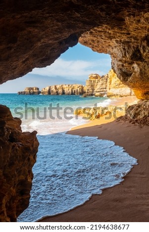 A natural summer beach cave at Praia da Coelha, Algarve, Albufeira. Portugal, vertical photo