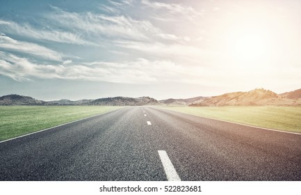 Natural summer landscape with asphalt road to horizon