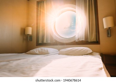 Natural Sunlight Shining Through Ship Window In Craft Cabin With Bed. View On Sea. Luxury Cabin On Ferry Boat Or Cruise Liner. Sea Cruise Vacation Trip Travel Concept