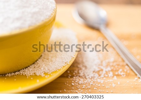 Natural sweetener sorbitol is poured from the cup. Selective focus, closeup.