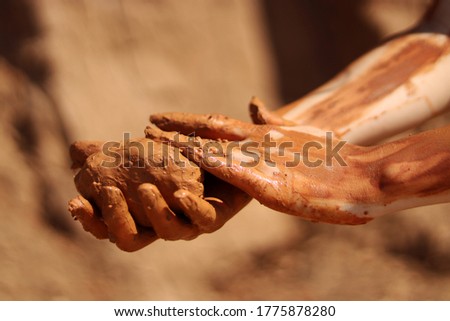 Natural terracotta clay piece held in hands. Wet clay material for sculpture or modeling