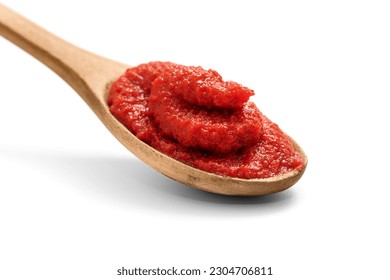 Natural tomato puree in wooden spoon isolated on white, including clipping path