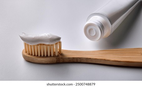 Natural toothpaste on a bamboo toothbrush. Bamboo toothbrush on white background. Wooden eco toothbrush.