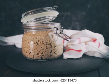 Natural Wild Yeast Culture. Active Rye Sourdough Starter In Glass Jar On Dark Wooden Background