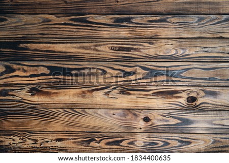 Natural wooden background with burned texture.