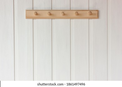 natural wooden empty hanger on a white wall. rustic interior as background, copy space.