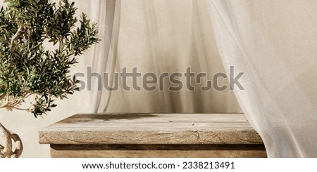 Natural wooden table and organic cloth with olive tree plant. Product placement mockup design background. Outdoor tropical summer scene with rustic vintage countertop display.