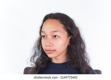 A naturally beautiful and pensive Filipino woman in her late teens without makeup. Fresh cute face isolated on a white backdrop. - Shutterstock ID 2149773443