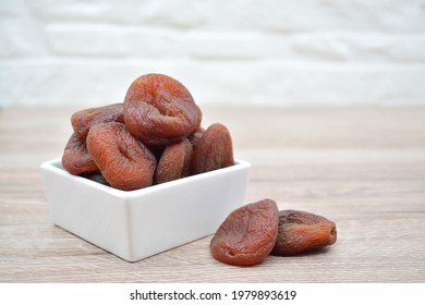 Naturally dried apricots in and around a square bowl
