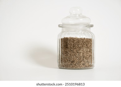 naturally dried organic cumin seeds in glass jar on white surface spice food. herbs. Caraway seeds, macro. close up, copy space stock image. spices. Persian cumin.  - Powered by Shutterstock