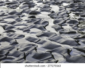 자연 추상: 미국 워싱턴 주 올림픽 반도 해변에 있는 모래를 가로질러 해일로 이루어진 작은 수영장의 패턴 스톡 사진