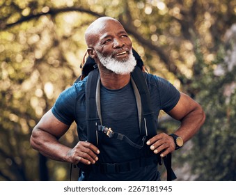 Nature, backpack and senior black man hiking in a forest for exercise, health and wellness. Sports, athlete and happy elderly African male hiker in retirement trekking in the woods on adventure trail - Powered by Shutterstock